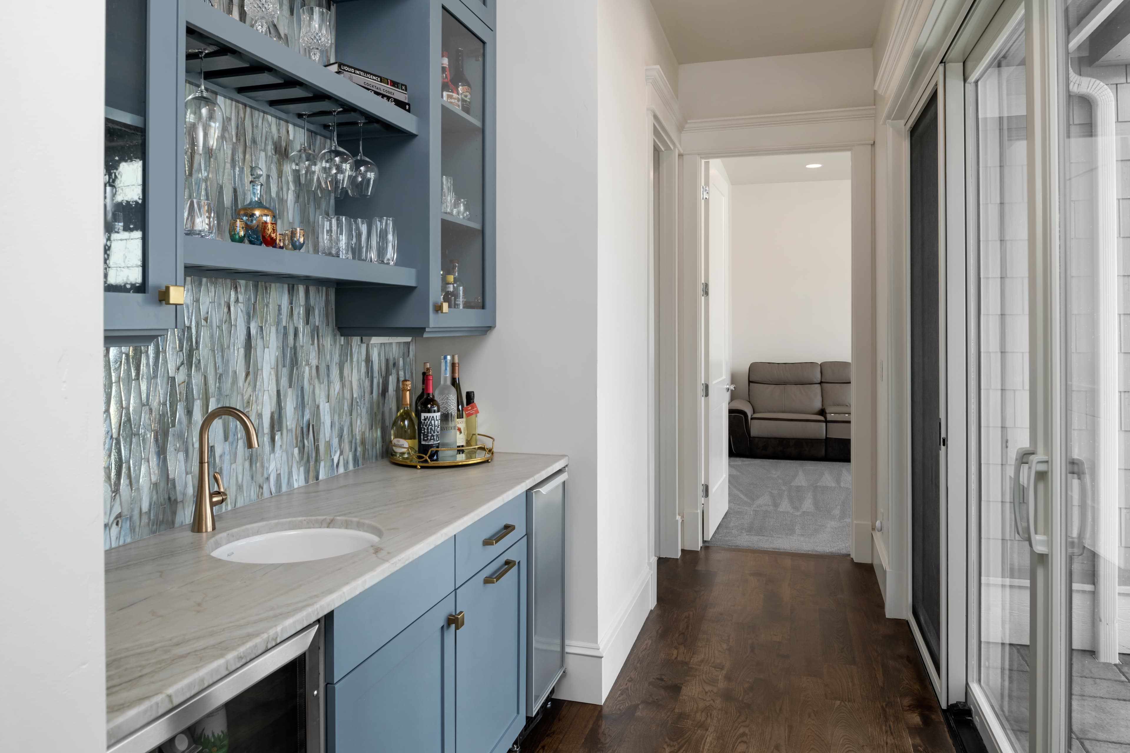 Blue wet bar with stone countertop and tile backsplash